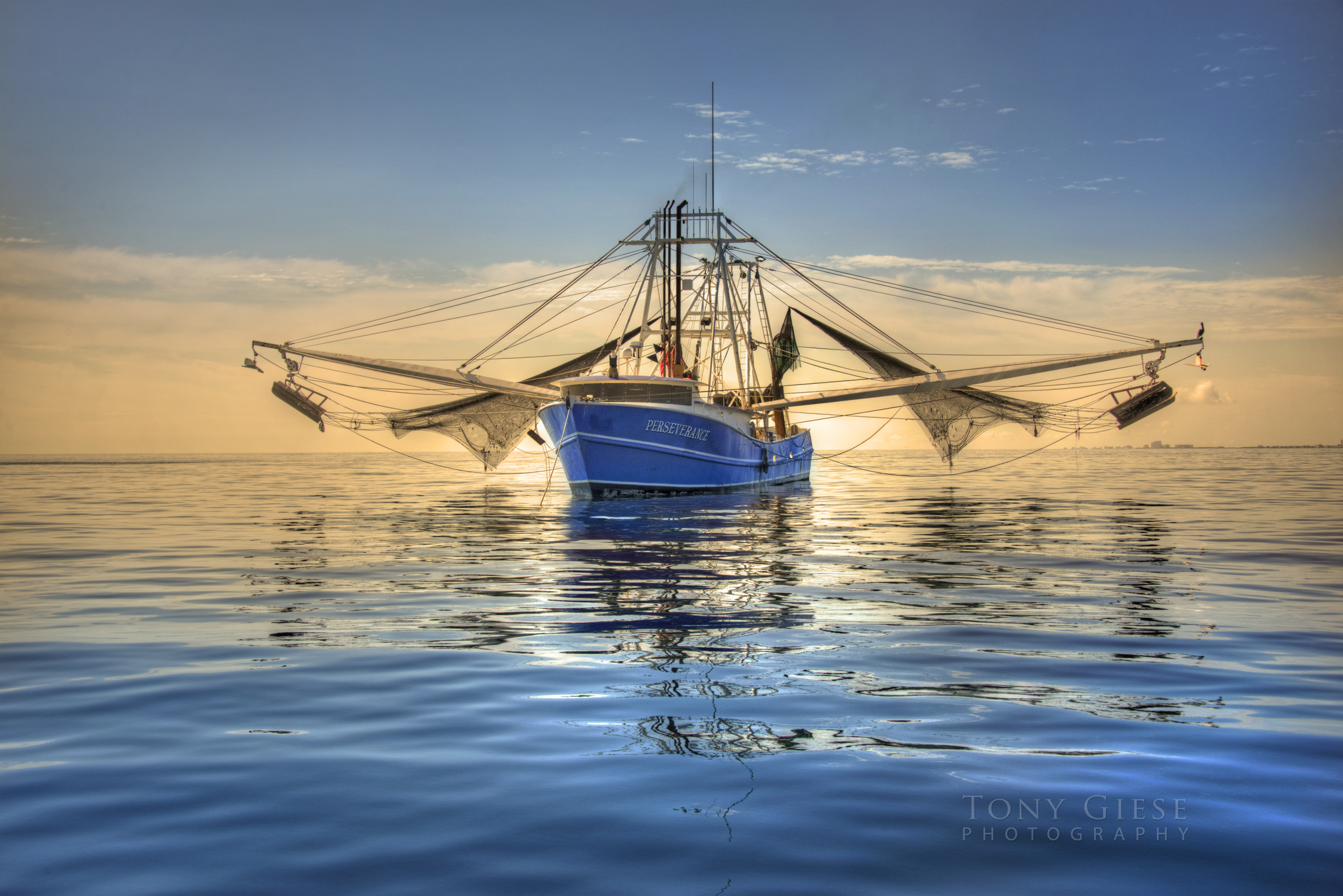 Shrimp boat resting with nets up. Upon calm ocean. Offshore Daytona Beach.