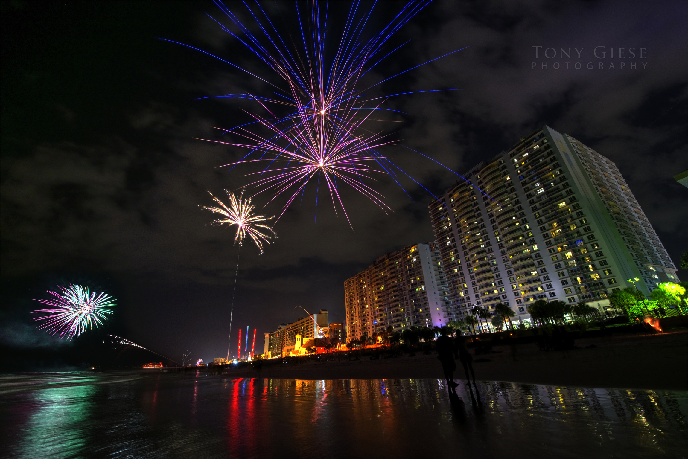 Perspective view of fireworks going off up and down Daytona Beach.